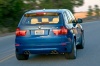 Driving 2013 BMW X5 M in Monte Carlo Blue Metallic from a rear right view